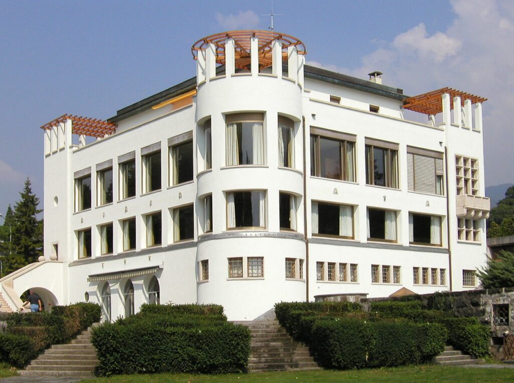 A white modernist villa standing in its own grounds